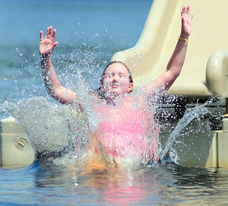Katie Holmes hits the water in Three-Cornered Pond, coming off a slide on Tuesday in Augusta's Bicentennial Nature Park. The park on Route 3 is open to Augusta residents and their guests daily, from 11 a.m. to 7 p.m., through Labor Day.