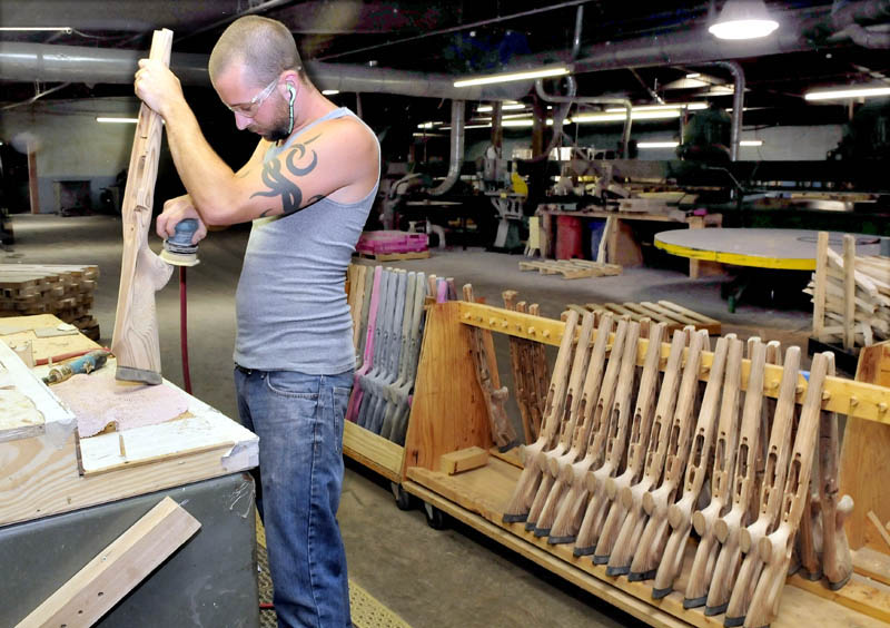 Cousineau Wood Products employee John Campbell sands a gun stock beside other styles being made at the North Anson company on Monday. The company is hoping to double its workforce with grant money that will allow it to expand.
