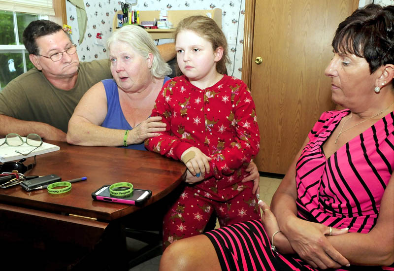 Kayla Veilleux, 14, listens as her parents, Bob and Venita, talk about her getting a bone marrow transplant at their home in Oakland. Listening at right is Liz Steele, who has helped with fundraising and supported the family.