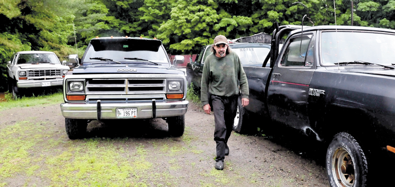 Keith Melancon walks past several trucks in need of repair at his Town Farm Road property in Farmington.