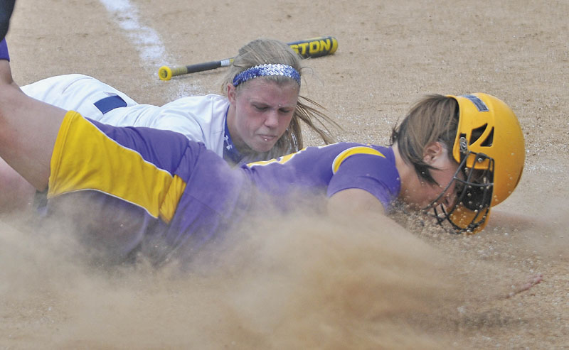 Bucksport High School's Debbie White dives safely across home plate as Madison's Savanna Kandiko tries to apply the tag in the fourth inning of the Class C softball state championship game Saturday in Brewer. Bucksport defeated Madison 7-0.