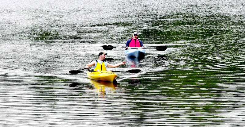 Mike Eldredge, front, and Keith Shorey drift on Messalonskee Stream in Waterville while trolling for fish on Monday.
