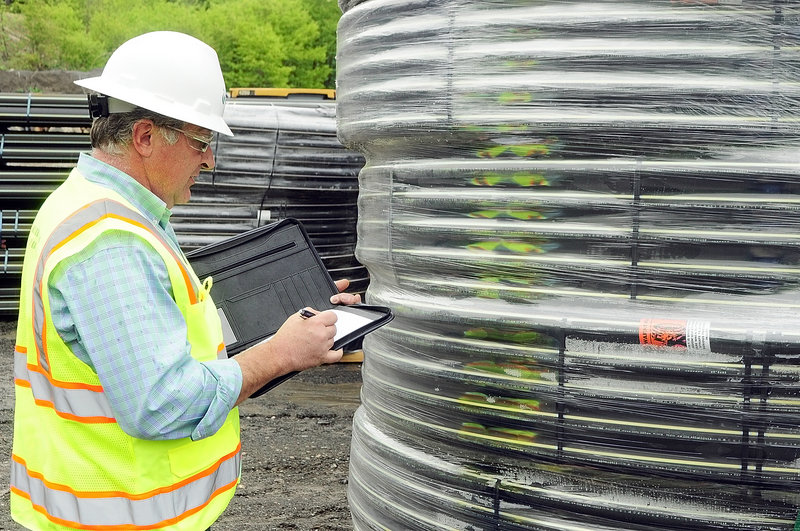 Bruce Madore, director of engineering and construction, looks over natural gas pipes in the Summit Natural Gas of Maine yard in Augusta.