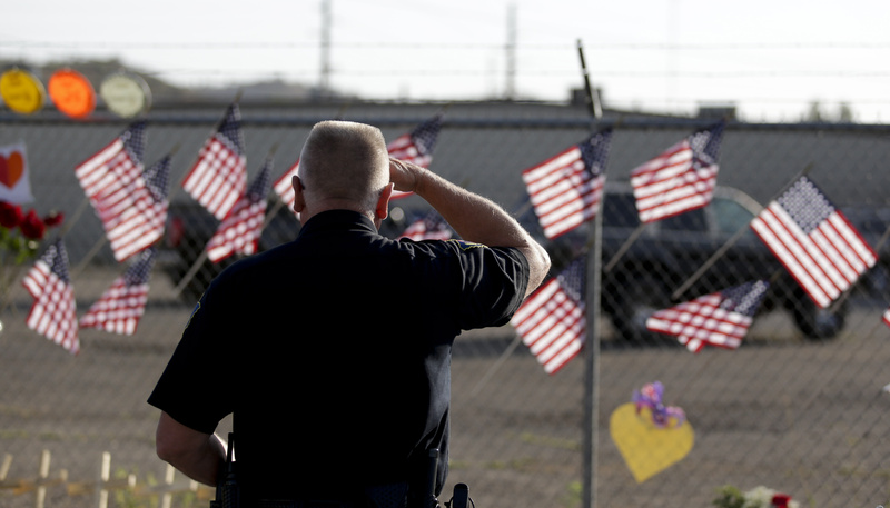 George Murphy of the Yavapi Tribal Police pays his respects at a makeshift memorial outside the Granite Mountain Hotshot crew fire station Tuesday in Prescott, Ariz., honoring 19 firefighters killed battling a wildfire near Yarnell, Ariz., Sunday.