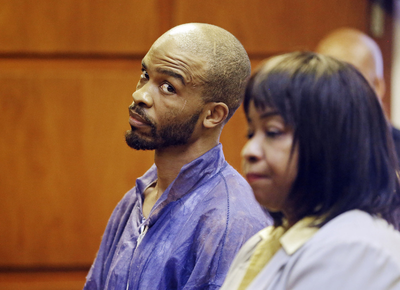 Michael Madison glances at court-appointed attorney Marlene Rideenour during his arraignment in East Cleveland on Monday. Madison has been charged with aggravated murder in the deaths of three women found in garbage bags in the city over the weekend.