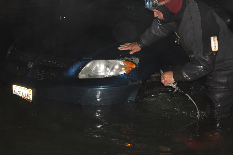 Rescue diver Travis Preston, a Jonesboro firefighter, hooks up a tow line to a minivan in the water at the scene of the double fatal accident Tuesday evening in Roque Bluffs.