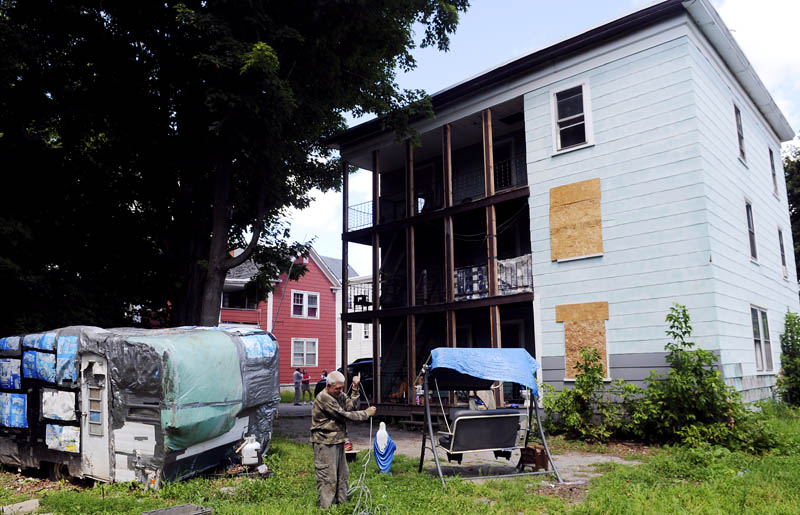 Joseph Vigue wraps up an antenna cable outside the apartment he's shared with his brother and uncle, at 6 York St. in Augusta, today after city code enforcement, fire department and health officials ordered tenants to vacate the building due to unsafe conditions.