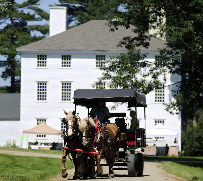 John Sczymecki, of Hideway Farms in Topsham, pulls visitors at the Dresden SummerFest on Sunday at the Pownalborough Court House in Dresden with his team of Belgians.