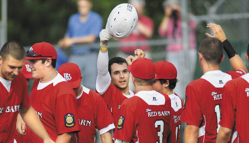 Way to go: Tayler Carrier, with helmet, is congratluated at home plate during The Red Barn’s 12-4 win over Madison in the American Legion baseball Zone 2 tournament Monday in Augusta. Carrier had two home runs and a triple for The Red Barn, which won the Zone 2 title and earned a berth in the state tournament with the win.