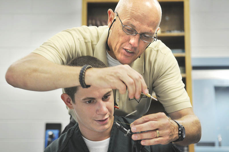 Inmate Todd McCrary learns to tie a fishing fly from corrections Sgt. Alan Gregory on Tuesday, in a conference room at the Kennebec Country Correctional Facility in Augusta.