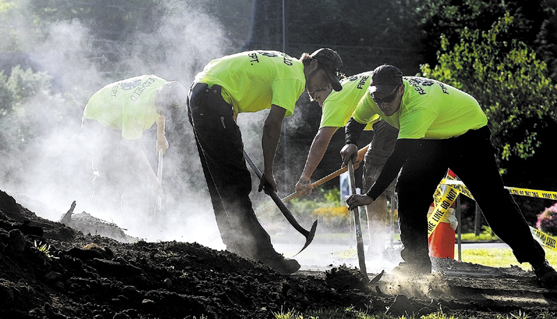 Readfield firefighters shovel dirt of the top of steel plates covering their bean hole beans in 2011 during Readfield Heritage Days. Readfield’s bean hole supper is Saturday from 4:30 to 6 p.m. at the Readfield fire station.