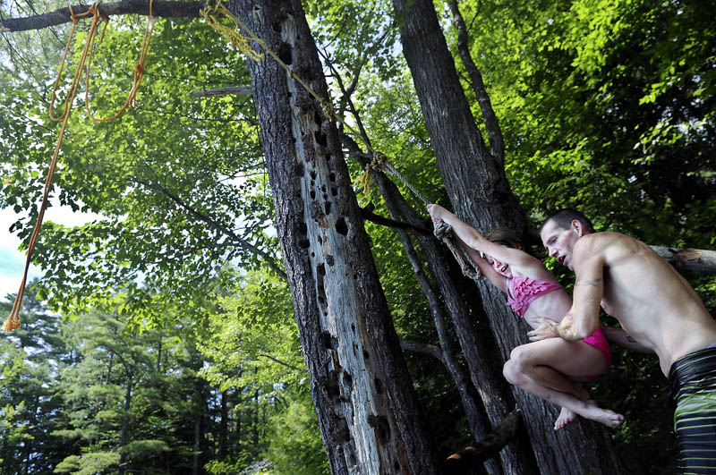 Nick Williams gives his daughter, Kiera, 7, a push on a rope swing Sunday while swimming in temperatures above 90 degrees in Augusta. The heat wave is expected to persist for the rest of the week. Williams other daughter, Lexi Merrill, 12, also took the plunge from the rope.