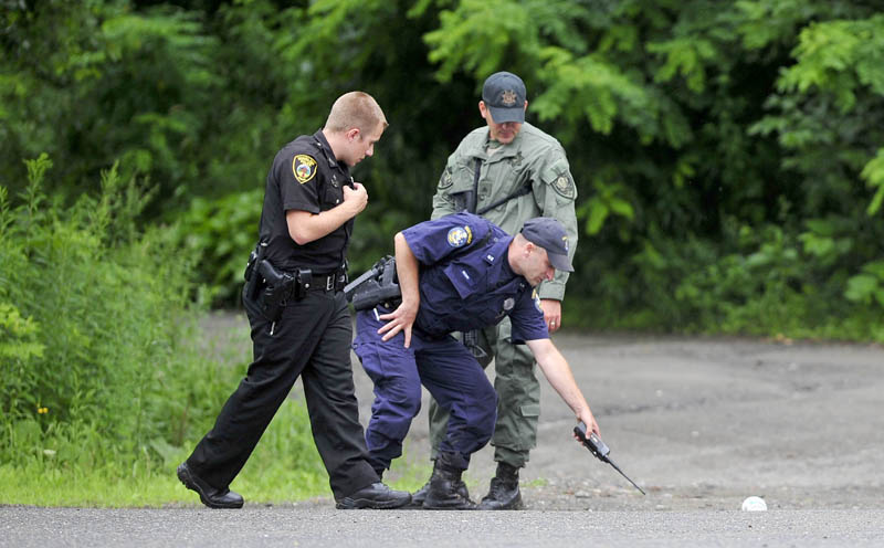 Police search for evidence behind Pleau's Market in Winslow after two men robbed nearby Bangor Savings Bank this morning on China Road in Winslow.