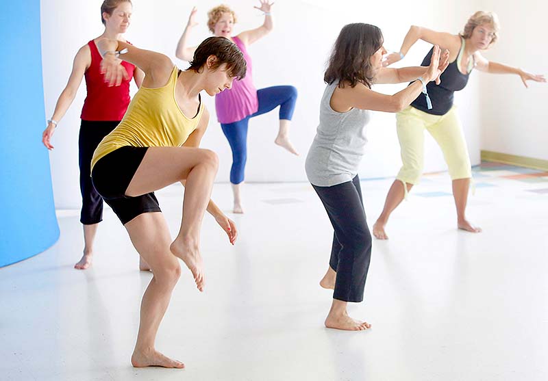 Liz Pettingill of Portland, left, participates in the 5 Rhythms of Dance class during YogaFest at the East End School in Portland on Sunday.