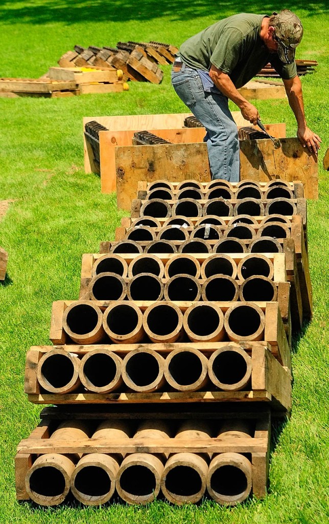Chris Henderson nails racks of launch tubes between sheets of plywood on Thursday at the Eastside Boat Landing in Augusta.