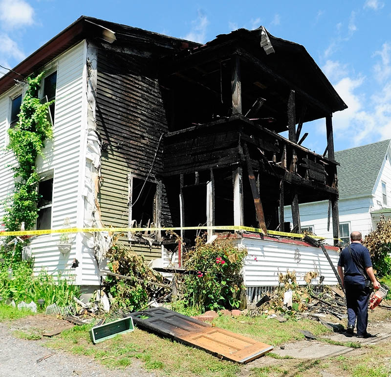 Augusta firefighter/paramedic Art True inspects 62 Washington Street on Friday, the morning after a fire heavily damaged the six-unit building in Augusta.