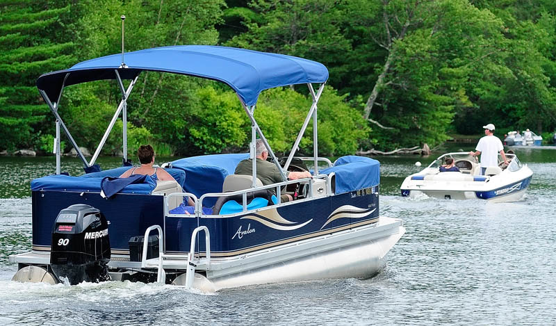 Three boats head out of Belgrade Lakes village on Mill Stream, toward Great Pond, on Thursday in Belgrade.