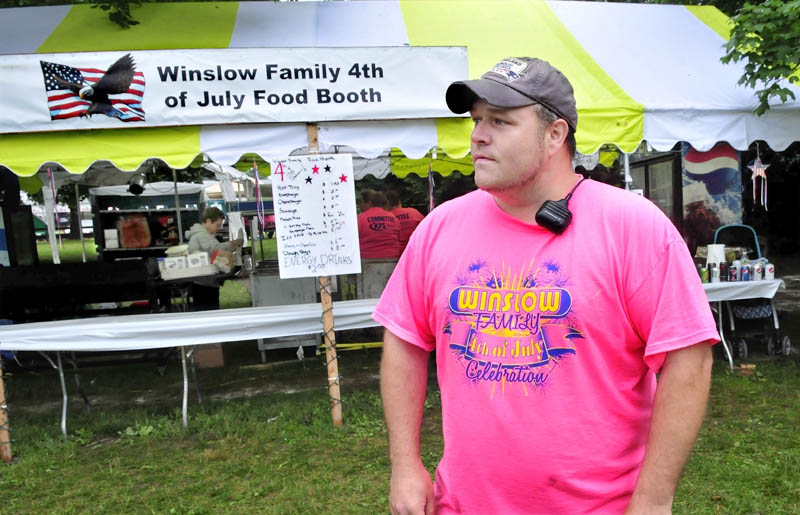 Kevin Douglass, chairman of the Winslow Family 4th of July celebration, speaks in front of a concession stand devoid of customers on a drizzly Tuesday. Douglass said the weather has kept attendance down during the day.