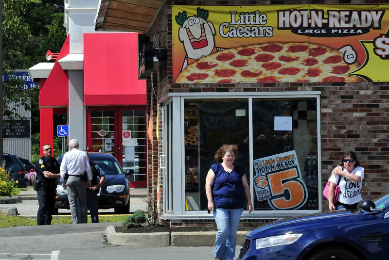 Customers were turned away at Little Caesar's restaurant in Waterville, as Waterville and state police, including Sgt. Lincoln Ryder, left, and Detective Alan Perkins, converged at the scene after a report of a robbery this afternoon.