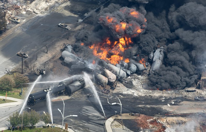 In this July 6 photo, flames and smoke rise from railway cars that were carrying crude oil after derailing in downtown Lac Megantic, Quebec, Canada, devastating the downtown and killing at least 50. (AP Photo/The Canadian Press, Paul Chiasson)