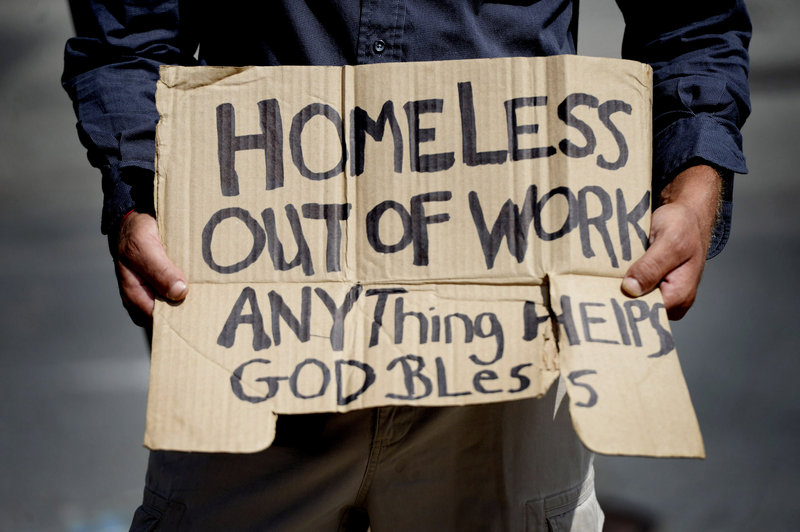 A man panhandles at the St. John Street/Park Avenue intersection in Portland in this 2014 file photo.