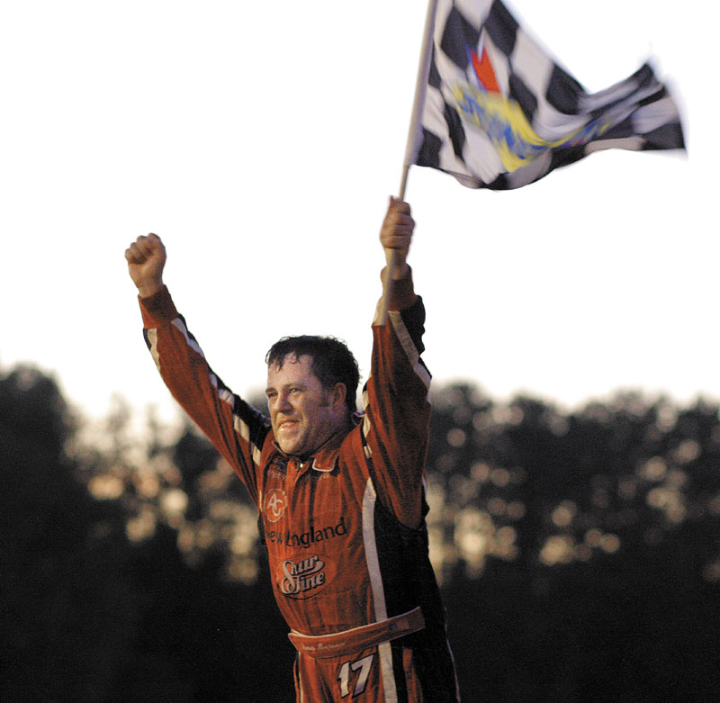 VICTORY LANE: Travis Benjamin raises the checkered flag after winning the 40th annual TD Bank 250 on Sunday at Oxford Plains Speedway in Oxford.