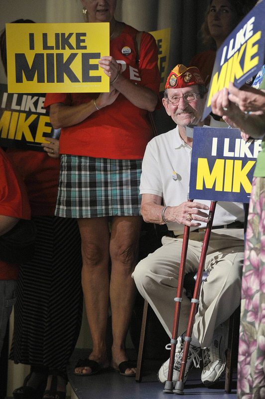 Maurice “Mo” Marquis, wearing a Marine Corps League cap, shows his approval of U.S. Rep. Mike Michaud’s run for governor at the Franco-American Heritage Center in Lewiston on Thursday. The Democrat’s rivals, incumbent Republican Gov. Paul LePage and independent Eliot Cutler, promise a challenging race.