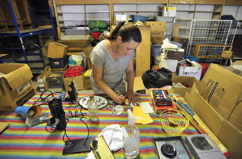 Janice Giggey, 38, of Madison, prices merchandise at the West Side store at 33 Madison Ave. in downtown Madison today.