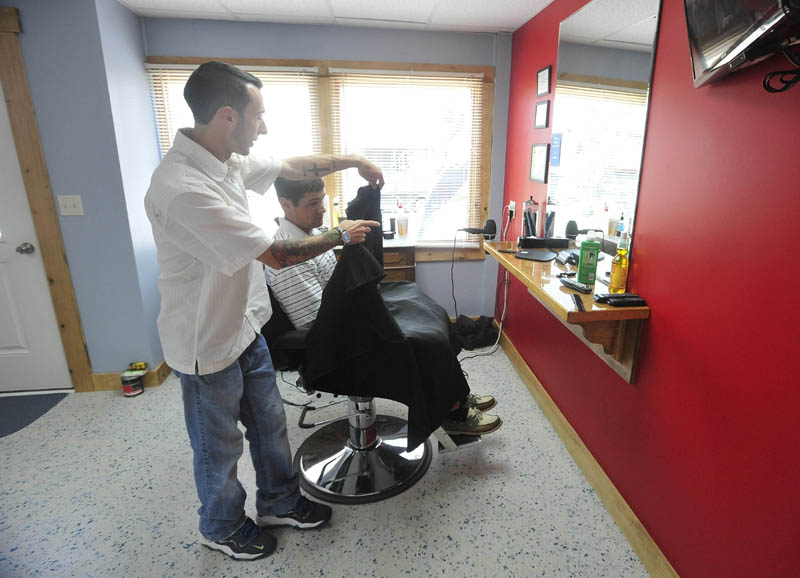 Derrik Vigue finishes up a cut on Josh Gilbert, 23, of Oakland, during a cut at Faded Lines Barber Shop at 99 Church St. in Oakland on Thursday.