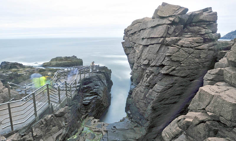 Tourists wait for the right wave to roll in to Thunder Hole at Acadia National Park on Mount Desert Island recently. Thunder Hole is a primary feature of Acadia National Park. When the right wave rolls in to the inlet, a thunderous sound is made.