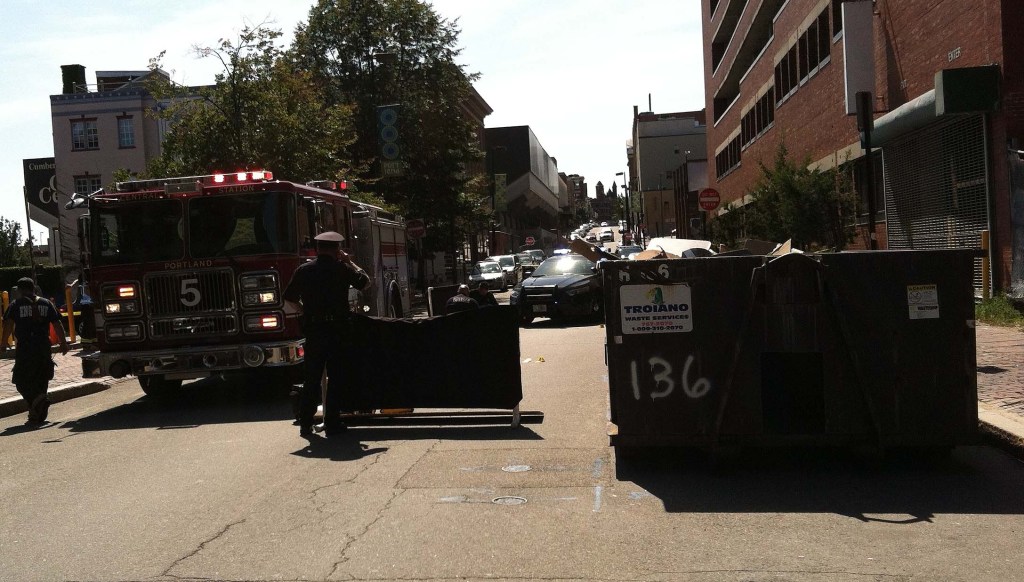Portland police use a screen to prevent passers-by from seeing the investigation of a man’s death outside a parking garage.