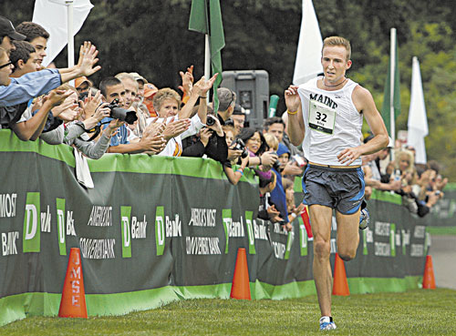 FIRST MAINE MAIN: Riley Masters of Veazie holds up his Maine jersey for cheering spectators as he sprints toward the finish of the TD Beach to Beacon 10K road race Saturday. Masters was the first Maine man to finish the race with an unofficial time of 30 minutes, 18 seconds.