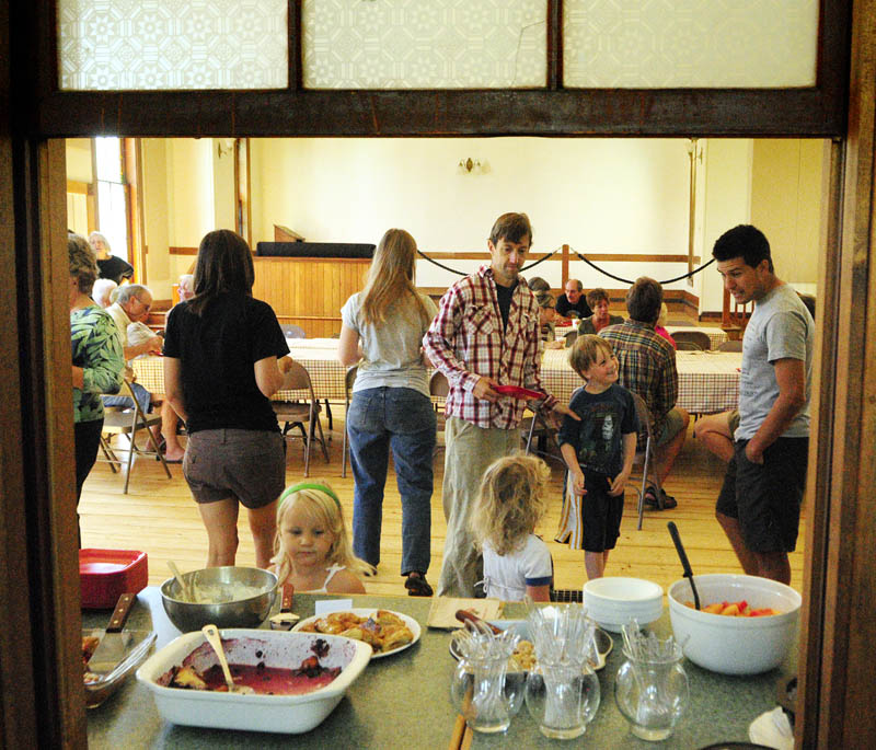 A kitchen window frames a view of the weekly community cafe fundraiser breakfast today at the Mount Vernon Community Center.