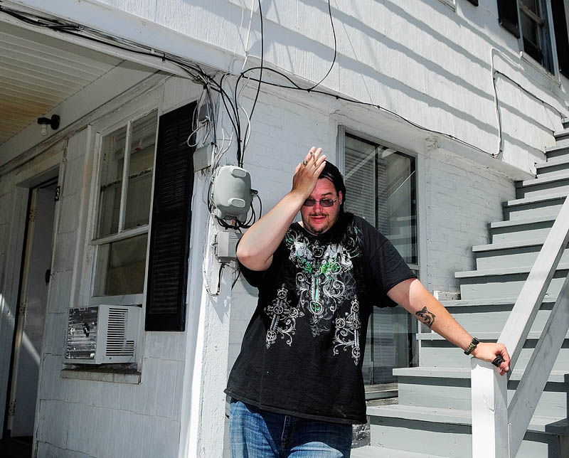 William Thorp puts his hand to his head while discussing have to move on short notice today at 9 Laurel St. in Augusta. The city ordered the nine residents of the building out by 3 p.m. today, citing "significant Life Safety Code deficiencies and some structural problems with the exterior porches and stairs."