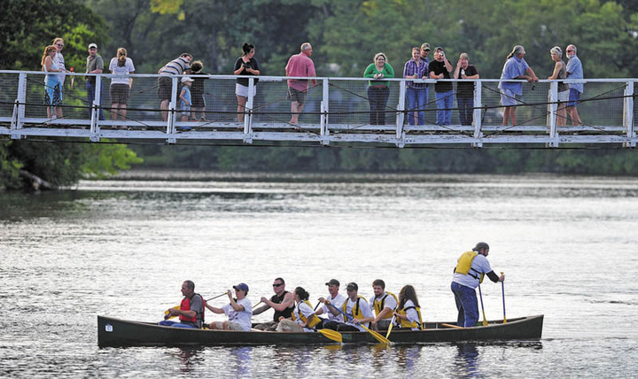 Team New Balance crosses the finish line at the suspension bridge in the Skowhegan River Fest boat races on the Kennebec River Thursday.