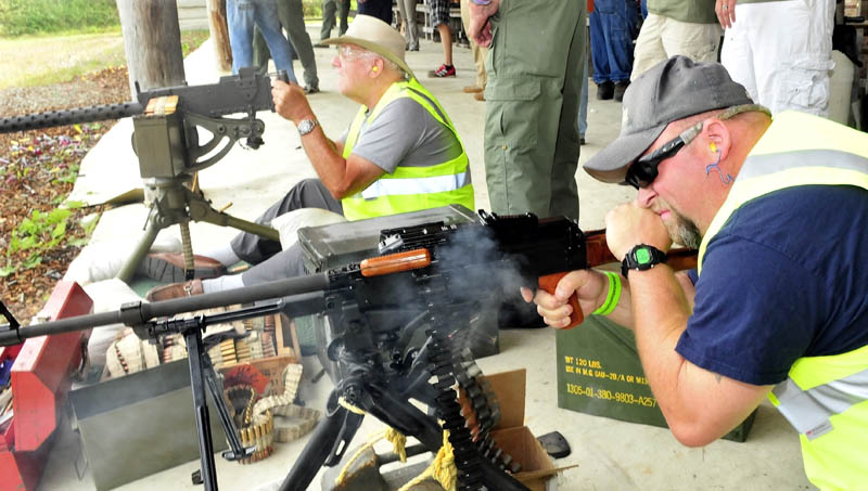 Nick Richards, right, of Winslow, fires a machine gun as Roland Marquis, of Augusta, prepares to fire another during the Wounded Warriors Machine Gun Shoot at the Williams Machine Gun Range in North Anson today.