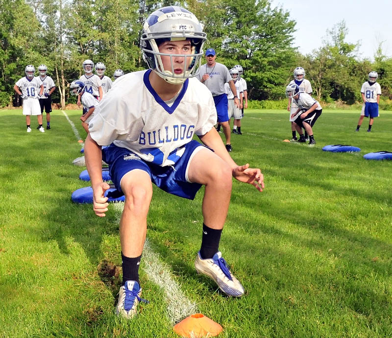 Time to get back to work: Trevor Lewis and his Lawrence High School football teammates run drills on the first day of practice Monday in Fairfield.