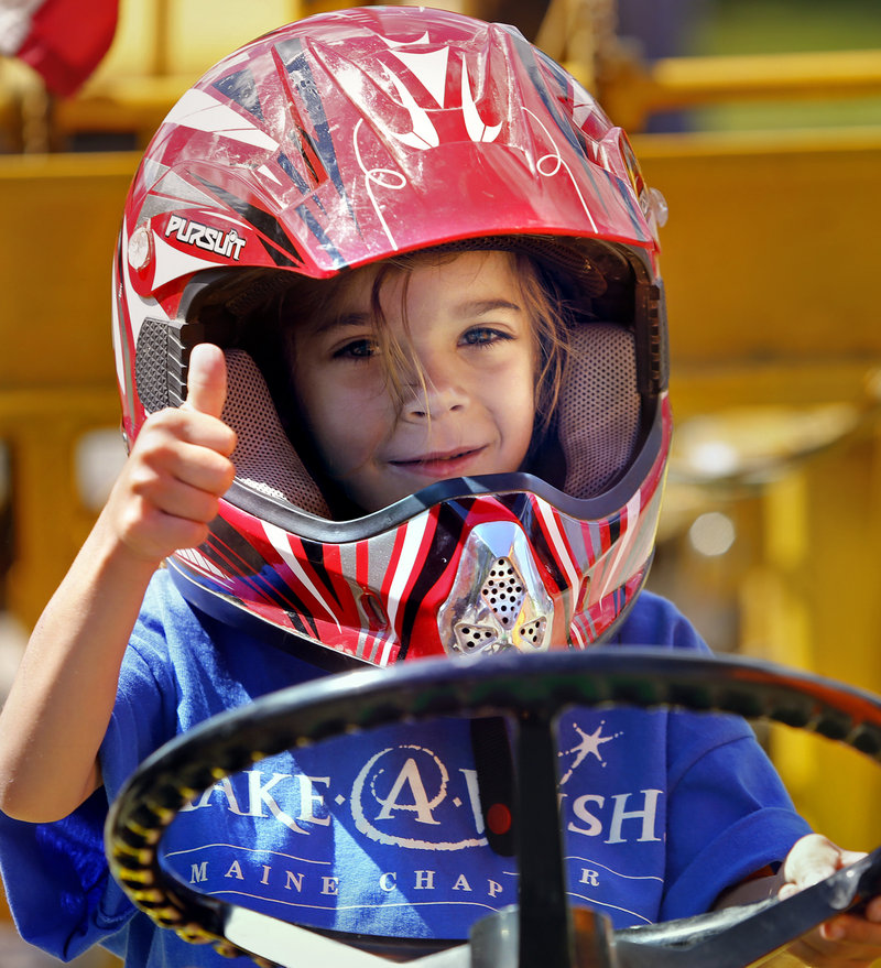 Paige Nadeau of Buxton drives a tractor. She and her brother Colby, 8, who also took part Sunday, have been diagnosed with catastrophic epilepsy.