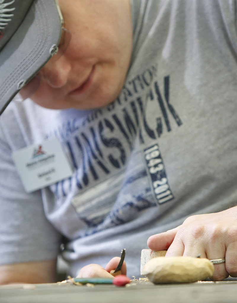 Richard Ruddell of Brunswick, a Navy veteran, works on a wood carving at Camp Wavus on Saturday.
