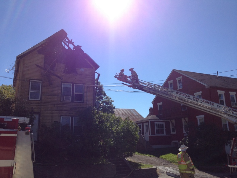 Windham firefighters finish cleaning up the scene Sunday morning at 13 Main St. in Windham after a man died in an early morning fire.
