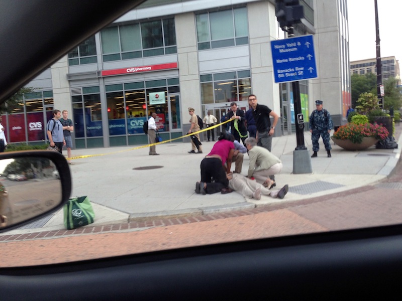 In this photo, which The AP obtained from Don Andres, shooting victim Vishnu Pandit is assisted on the sidewalk while awaiting the arrival of emergency medical personnel after coworkers took him by car from the Washington Navy Yard to receive medical attention Monday, Sept. 16, 2013, in Washington. Pandit died of his injuries. (AP Photo/Don Andres)