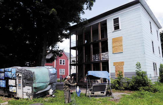 Joseph Vigue wraps up an antenna cable outside the apartment he shares with his brother and uncle at 6 York Street in Augusta after city code enforcement, fire department and health officials ordered tenants to vacate the building due to unsafe conditions.