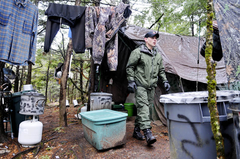 Staff photo by Andy Molloy District Game Warden Aaron Cross exits Christopher Knight's camp Tuesday April 9, 2013 in a remote, wooded section of Rome after police inspected the site where Knight is believed to have lived since the 1990s. Police believe Knight, who went into the woods near Belgrade in 1986, was a hermit who committed hundreds of burglaries to sustain himself.