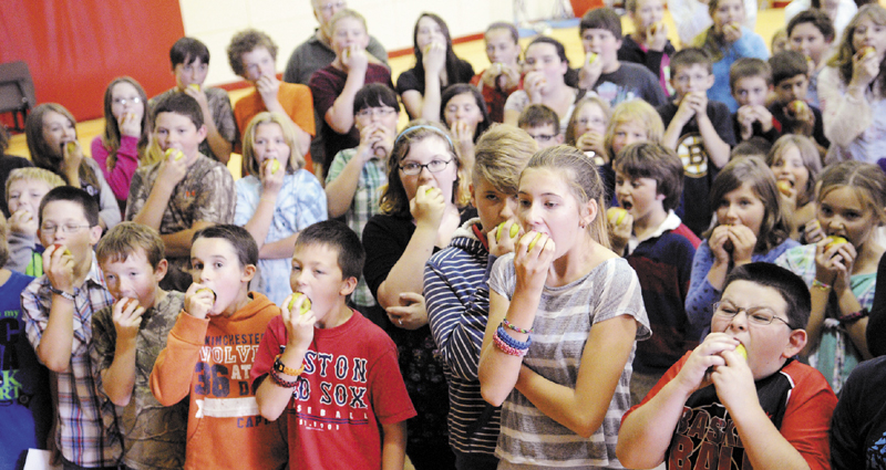 Whitefield Elementary School students take collective bites out of apples Thursday during a celebration of the locally grown fruit. Residents provided hundreds of apples to sample, all grown at local orchards, during the event, sponsored by the Focus on Agriculture in Rural Maine Schools.