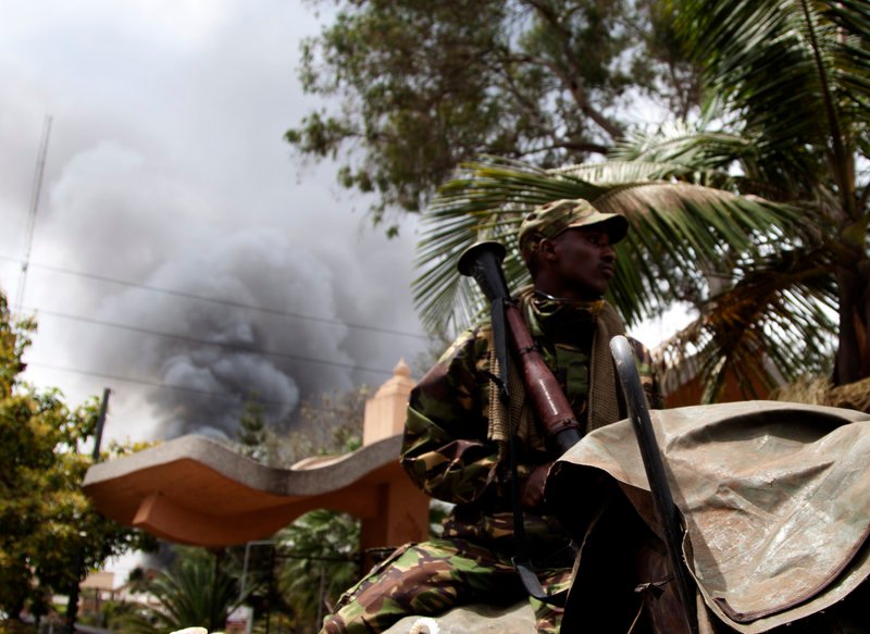 A soldier holds a RPG near the Westgate shopping mall in Nairobi, Kenya, as smoke rises from it, Monday Sept 23 2013. Islamic extremist gunmen lobbed grenades and fired assault rifles inside Nairobi's top mall Saturday, killing dozens and wounding over a hundred in the attack. A day after a Twitter post linked Maine to Saturday's terrorist attack in a mall in Nairobi, Kenya, law enforcement officials refused to say whether they are investigating the possibility that radical Islamist groups are trying to recruit new members in the state. (AP Photo/ Sayyid Azim)