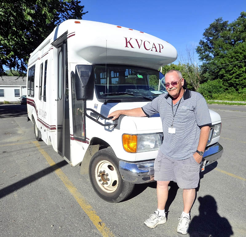 Mark Goggins stands next to his bus at the Kennebec Valley Community Action Plan office on Water Street in Waterville on Friday. KVCAP provided between 900 and a 1,000 rides a day to MaineCare patients before a contract with an out-of-state company, Coordinated Transportation Solutions, went in to effect, significantly reducing the organization's service, according to KVCAP administrators.