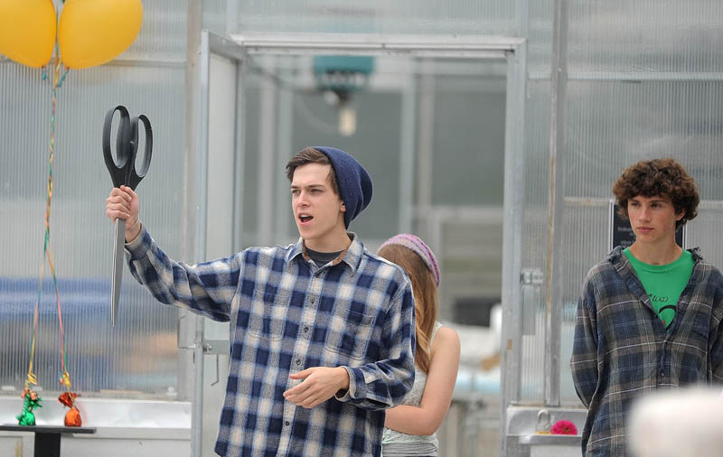 Tim Thompson, 17, a senior at the Maine School of Natural Sciences, holds up the novelty scissors as Jeff Chase, the agriculture specialist for the school, is introduced, during the dedication today of three greenhouses at the Maine School of Natural Sciences in Hinckley.