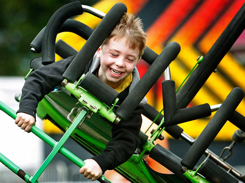 Ben Duda, 6, of Boston, Mass., flies for the first time on the Cliff Hanger ride with his grandfather, Fred Miller, of Freeport at opening day of the Cumberland County Fair on Sunday.