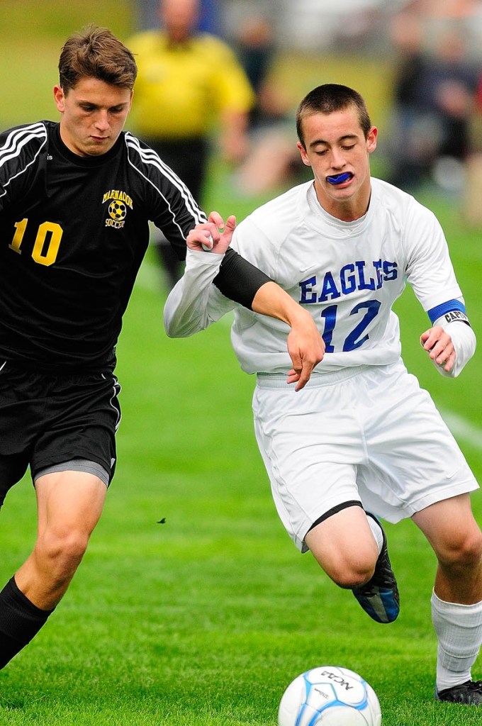 WHO’S GOT IT? Maranacook’s Nick Lacasse, left, and Erskine’s Ryan Rodrigue chase after a loose ball during Tuesday’s game at Erskine Academy in South China.