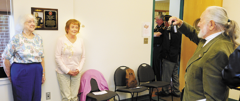 After a ceremony honoring Marine Corps First Sgt. Don "Woody" Hamblen, his sister, Gloria Sylvester, left, and daughter, Sherry Parkinson, have their picture taken in front of a plaque by Frank Smimmon on Thursday at the Winthrop Town Office. Hamblen, who lives in California, didn't attend.